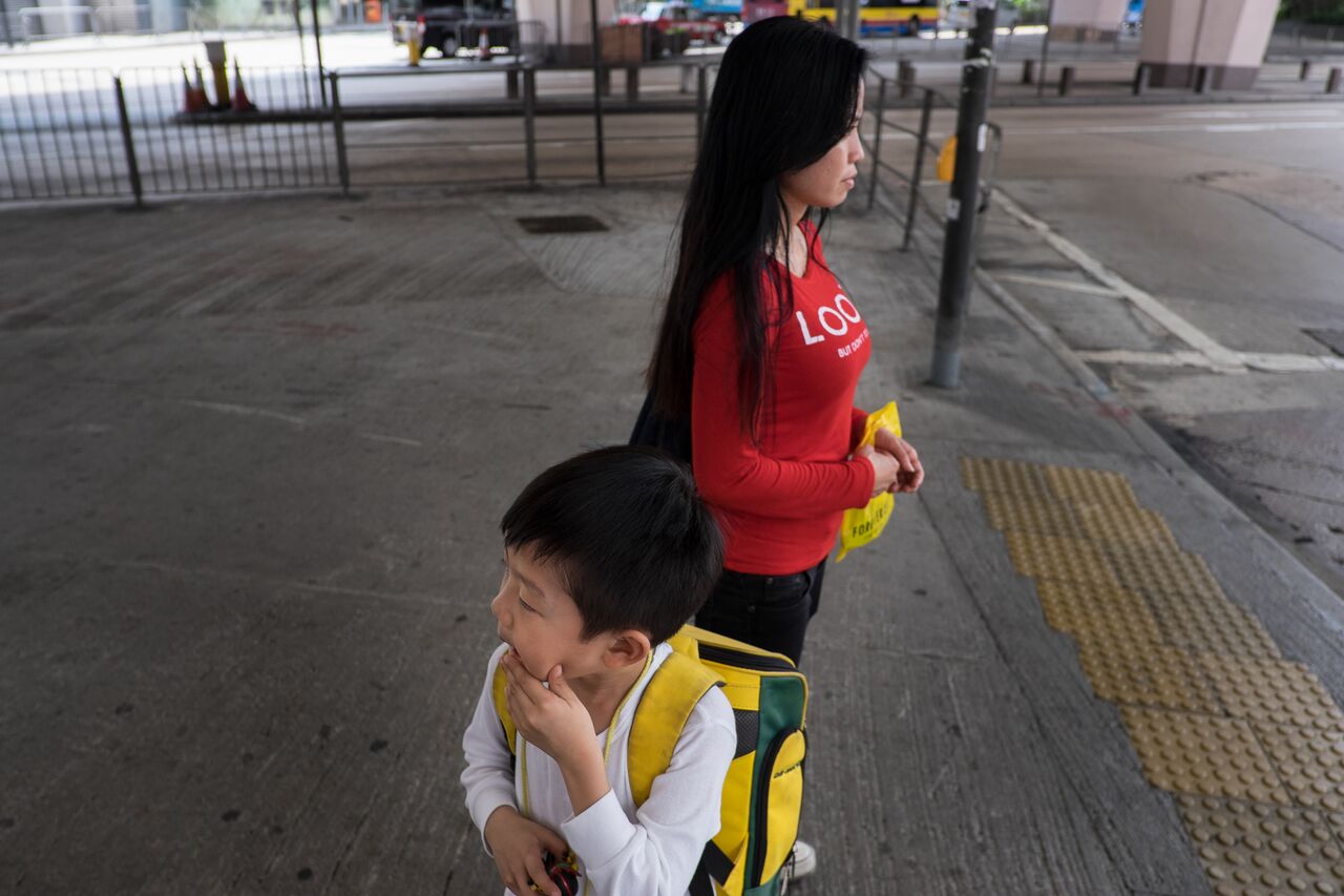 Okah, a domestic worker from Indonesia collects Fang Wai, the son of her employer from school. 