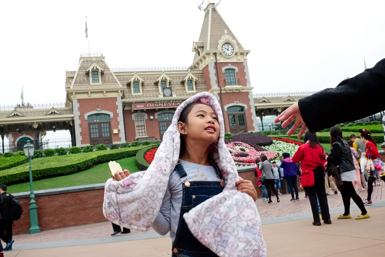 Bhing reaches out to her daughter Dominique at Hong Kong Disneyland during a rare visit by Dominique to see her mother. Most helpers can only see their children every two years at the end of their contract.