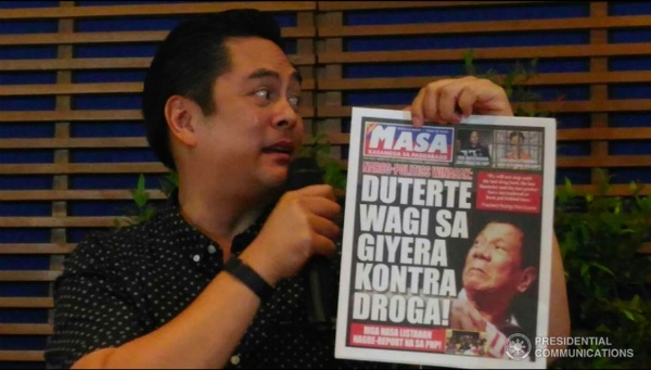 Presidential Communications Secretary Martin Andanar holds a copy of a state-run tabloid. FILE PHOTO