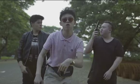 Brian, formerly known as Rich Chigga, sporting a pink polo shirt and a fanny pack in the music video for “Dat $tick”.