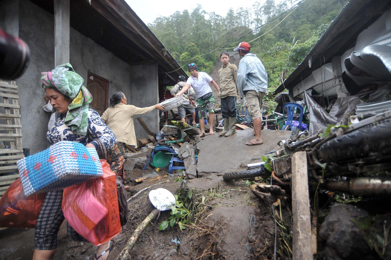 A woman carries her belongings from her damaged house after it was hit by landslide at Songan Village, Kintamani February 10, 2017. Photo: Nyoman Budhiana/Antara Foto via Reuters