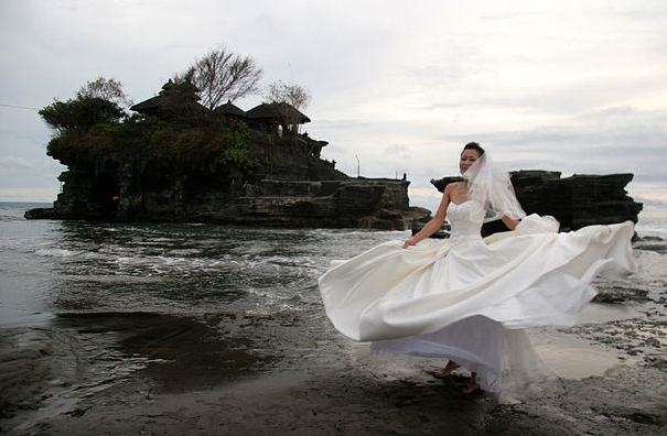A bride twirls at Tanah Lot temple in Bali. Photo: Wikimedia Commons