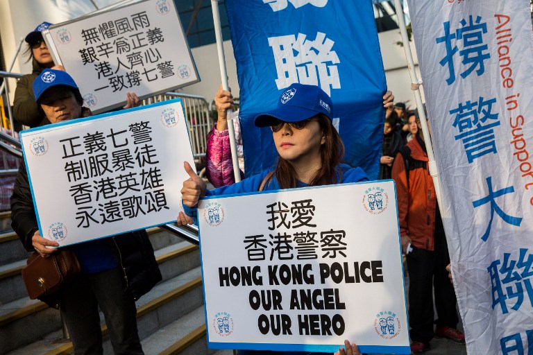 Supporters of the seven police officers, who were convicted of assaulting activist Ken Tsang during the 2014 pro-democracy Occupy protests, hold placards outside the District Court in Hong Kong on February 14, 2017.
Photo: Isaac Lawrence/AFP