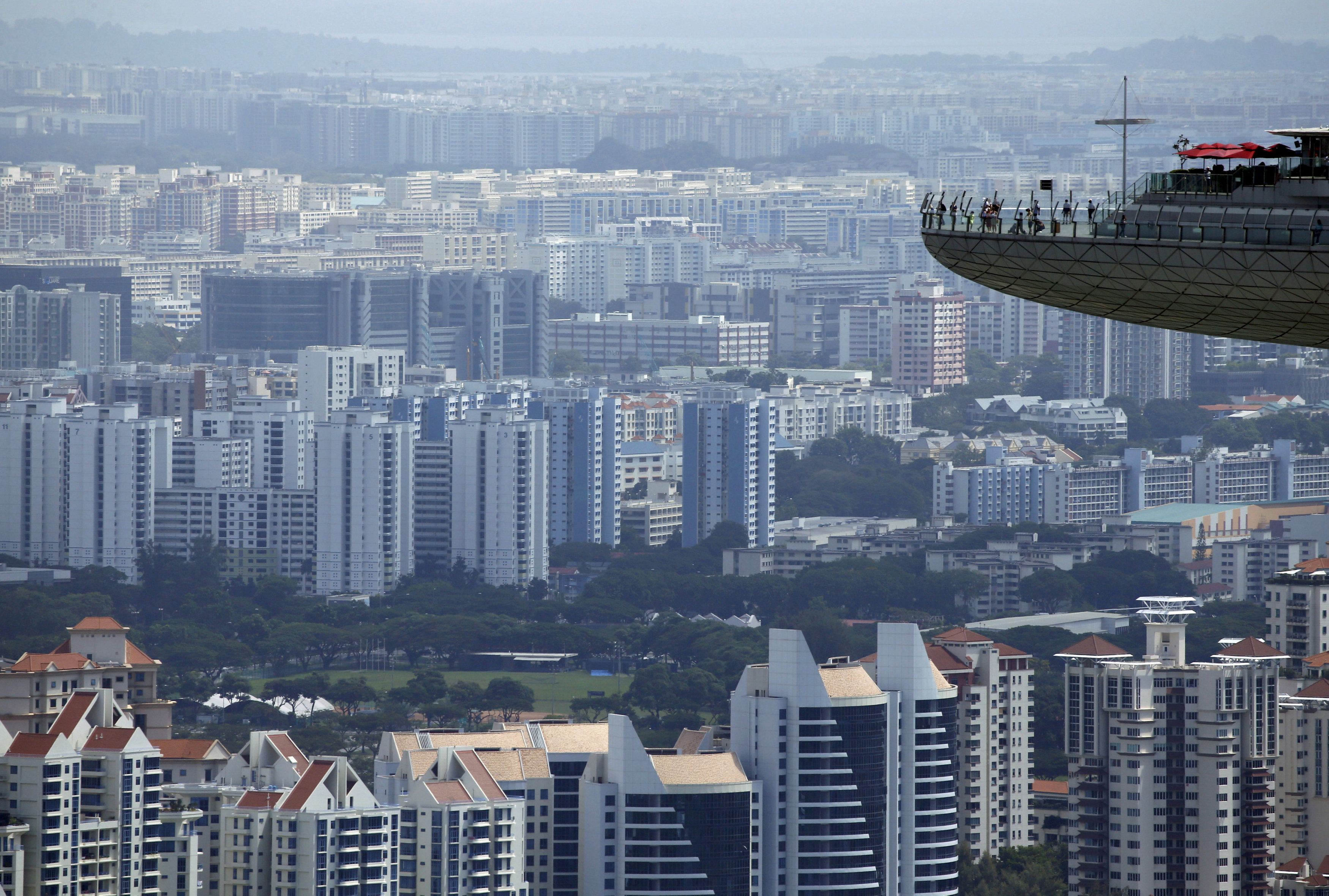 People look out from the observation tower of the Marina Bay Sands amongst public and private residential apartment buildings in Singapore. Photo: Edgar Su/ Reuters