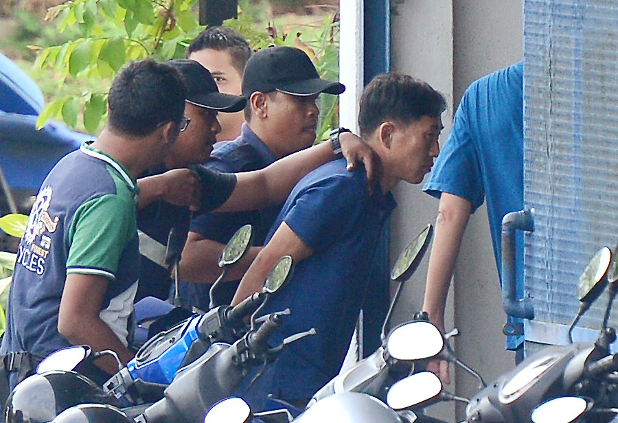 A North Korean man (R) identified by the Malaysian police as Ri Jong Chol and suspected by the authorities to be in connection with the murder of Kim Jong Nam, is taken to a police station in Sepang, Malaysia. Photo: Park Jung-ho /  REUTERS