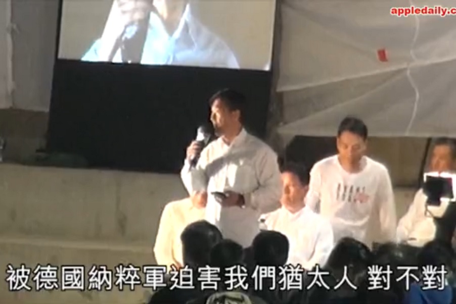 Station sergeant Chan speaking at the police rally, where he compared his colleagues who were convicted for beating a protester were just like the Jewish people routinely persecuted and massacred in Nazi Germany. Screenshot: Apple Daily