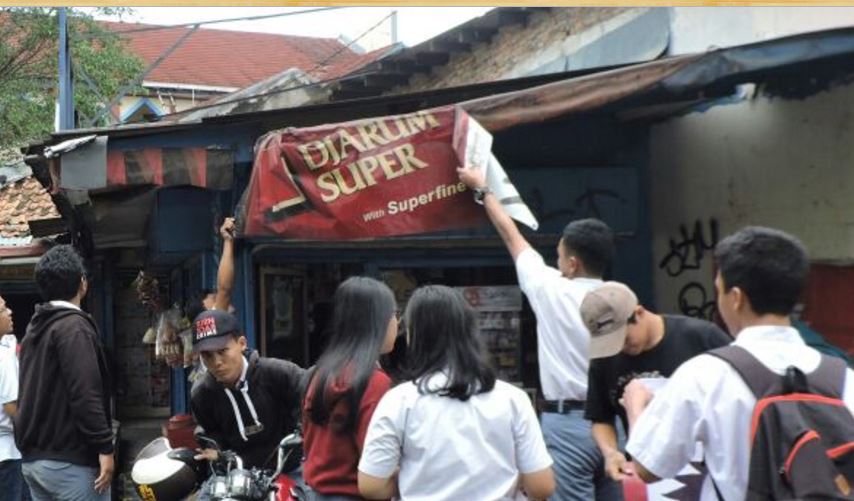 Indonesian students pulling down a tobacco advertisement as part of the #TolakJadiTarget campaign. Photo: Twitter / @KomnasPT