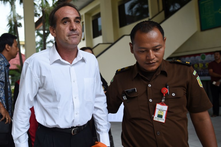 Australian businessman Giuseppe Serafino (L) is taken to a holding cell after his trial at a court in Denpasar on Indonesia’s resort island of Bali on March 14, 2017. Photo: Sonny Tumbelaka/AFP