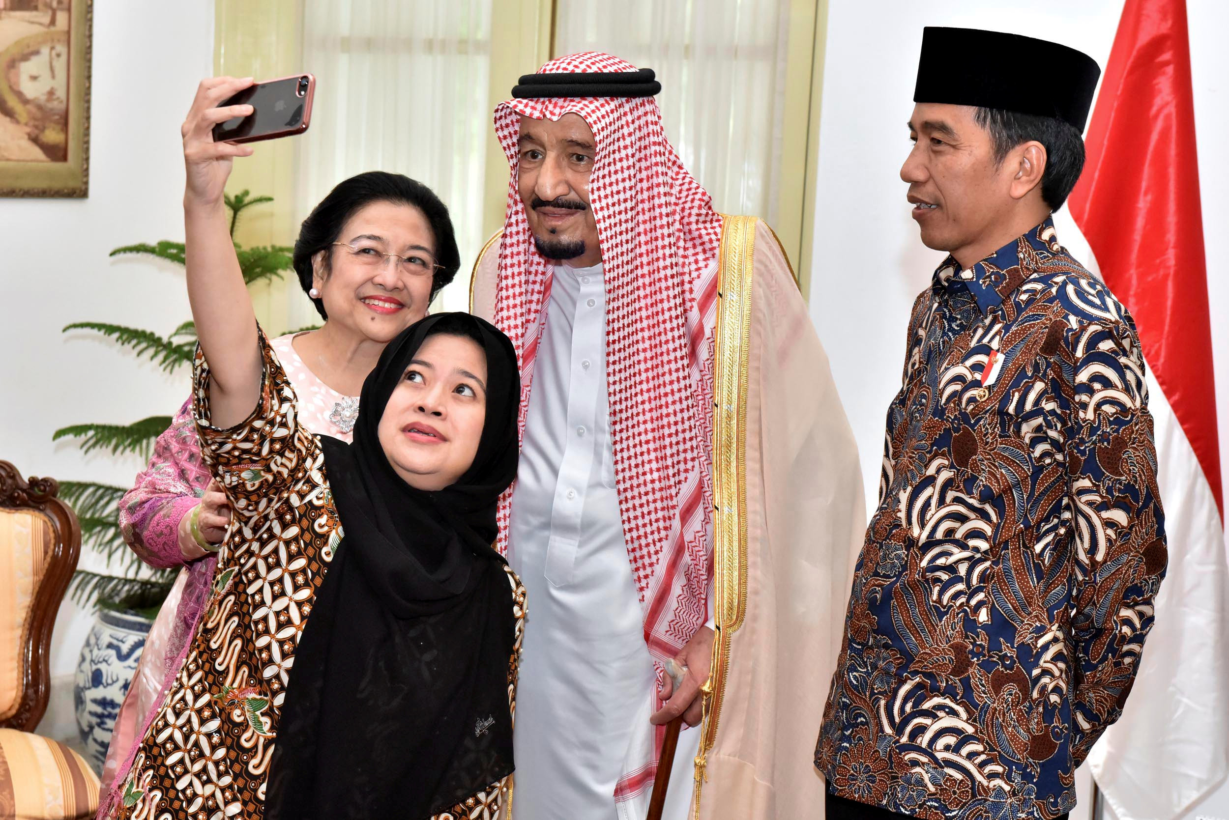 Indonesian President Joko Widodo (R) watches as former president Megawati Sukarnoputri and her daughter Puan Maharani, a minister in his cabinet, take a selfie with Saudi Arabia's King Salman (C) at the presidential palace in Jakarta, Indonesia March 2, 2017 in this photo taken by Presidential Palace Photographer. Presidential Palace Photographer/Agus Suparto/Handout via REUTERS