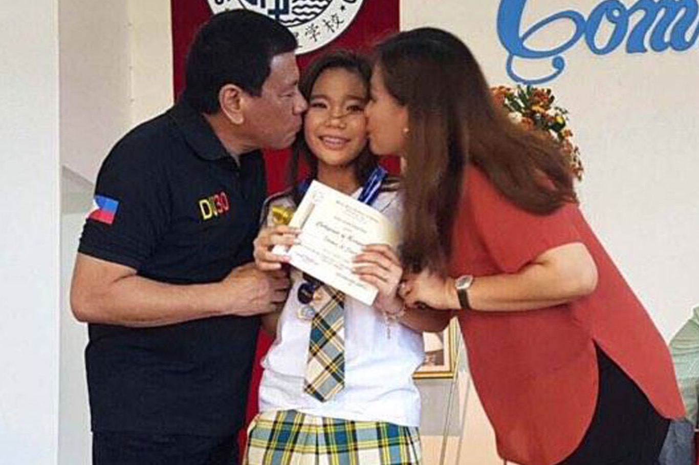 President Rodrigo Duterte and partner Honeylet Avanceña kiss their daughter Kitty who just graduated. PHOTO: Bong Go