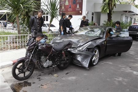 Policemen examine a damaged Ferrari at the Yoovidhaya home in Bangkok. Photo: Reuters