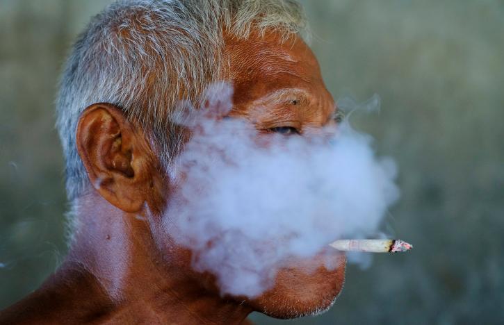 A worker smokes a cigarette during a break at a fabric factory in Solo, Indonesia Central Java province, August 11, 2016. REUTERS/Beawiharta/File Photo