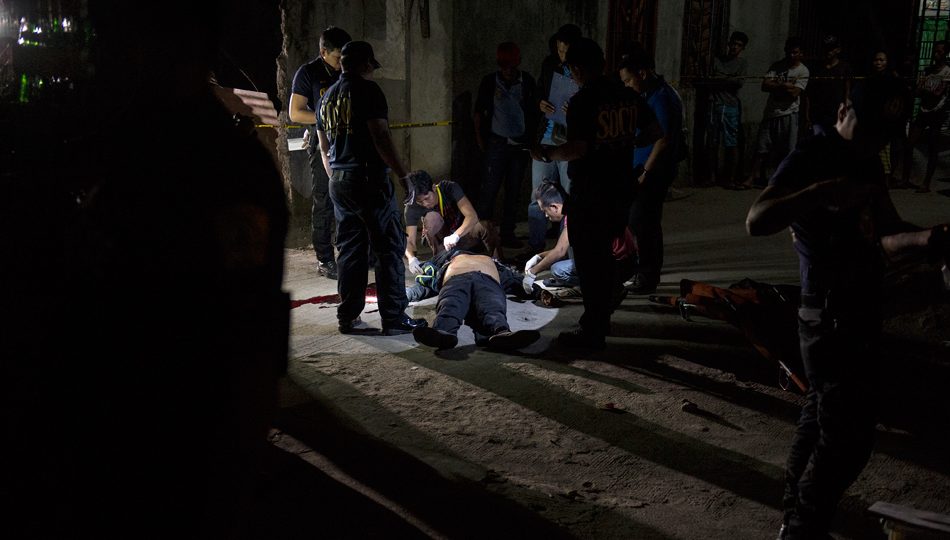 Police investigate the killing of an alleged drug user in Metro Manila. FILE PHOTO: Noel Celis/AFP
