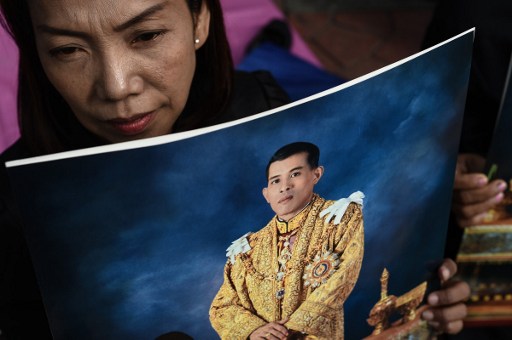 A woman holds an image of Thailand’s new King Maha Vajiralongkorn outside the Grand Palace in Bangkok on December 2, 2016. 
Photo: AFP /  Lillian Suwanrumpha
