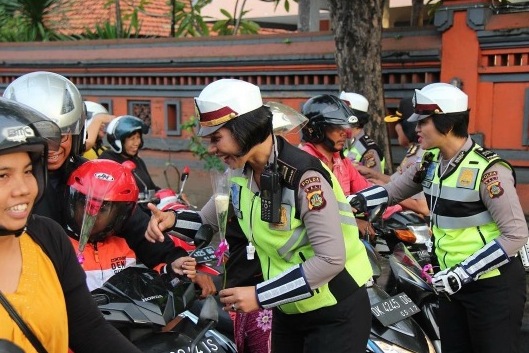 Policewomen hand out flowers to motorcyclists on Kartini Day. Photo: Polda Bali