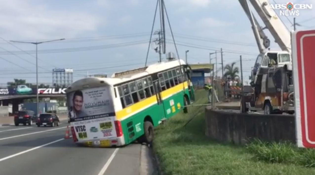 After falling off the elevated ramp at NLEX, the bus was towed out of the road. PHOTO: Screengrab from ABS-CBN footage