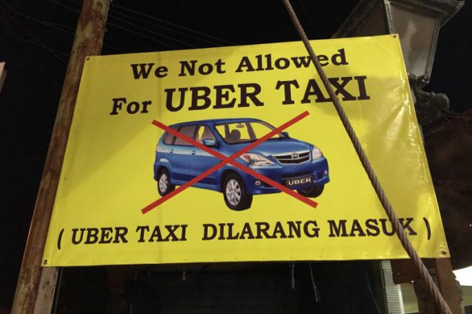Uber’s entrance into Bali has been super controversial. Drivers working for ‘traditional’ taxis and local drivers associations have made a point of getting signs like these put up to ‘protect’ their turf from the hot-new competition, Uber. Photo: Coconuts Bali