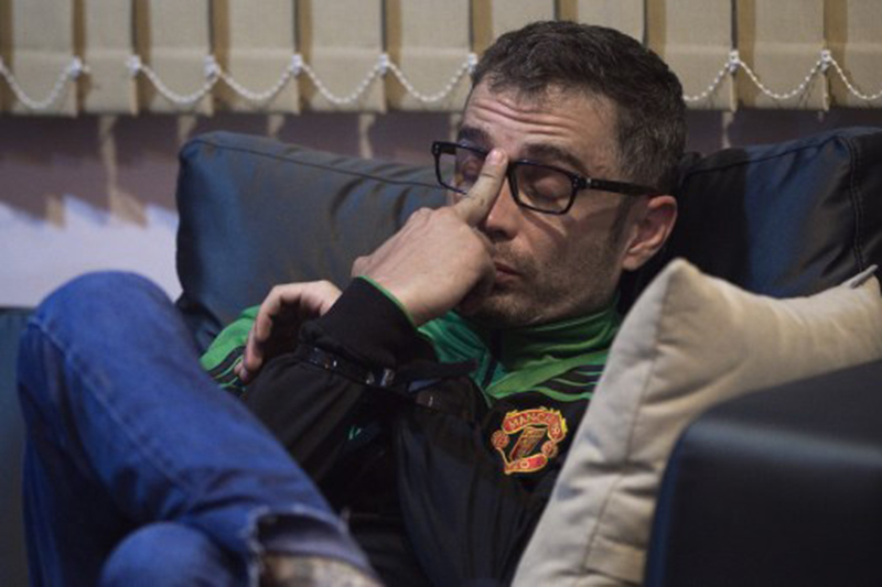 Spanish national Artur Segarra, 37, gestures on a couch while guarded by a police officer. Photo: AFP