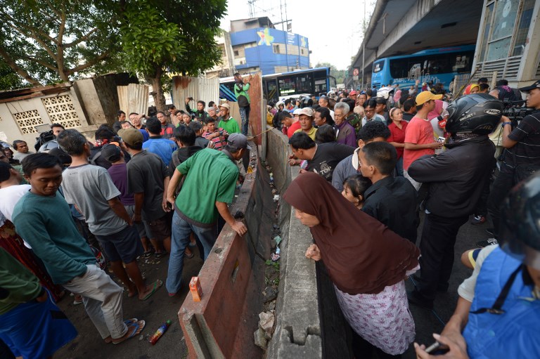Indonesian people gather at the scene where two bombers launched an attack, in Jakarta on May 25, 2017. A suicide bombing attack outside a busy bus terminal in the Indonesian capital Jakarta on May 25 killed three police officers, the latest assault to hit the Muslim-majority country as it struggles with a surge of terror plots. Photo: Adek Berry/AFP