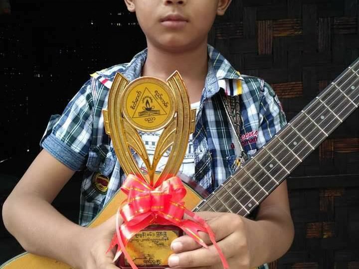 Okkar Phyo with a school prize that he won for his guitar skills. Photo: Facebook
