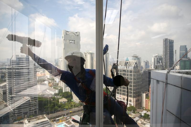 A worker cleans the windows of a building in Bangkok, Thailand, May 11, 2017. REUTERS/Athit Perawongmetha – RTS1640E