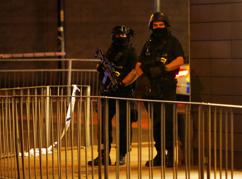 Armed police officers stand next to a police cordon outside the Manchester Arena, where U.S. singer Ariana Grande had been performing, in Manchester, northern England, Britain