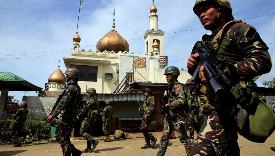 Government troops walk past a mosque before their assault with insurgents from the so-called Maute group, who have taken over large parts of Marawi City, southern Philippines May 25, 2017.  PHOTO: REUTERS/Romeo Ranoco