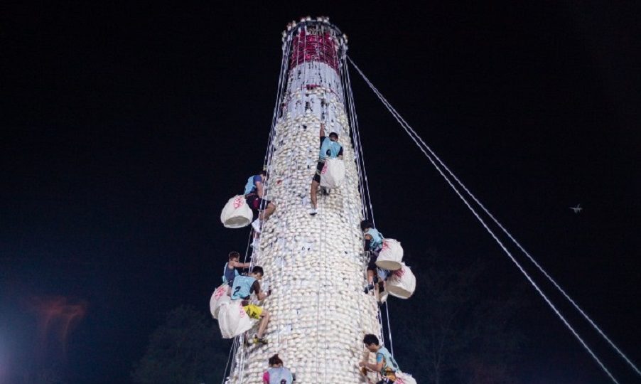 Competitors take part in a scramble up an 18-meter (60-foot) tower made from imitation buns during the annual Cheung Chau bun festival in Hong Kong, shortly after midnight on May 4, 2017.
Tens of thousands gathered in Hong Kong on May 3 for one of its most colorful festivals, a whirlwind of music and costume culminating in a dramatic climb up a precipitous “bun tower”. Photo: Anthony Wallace/AFP