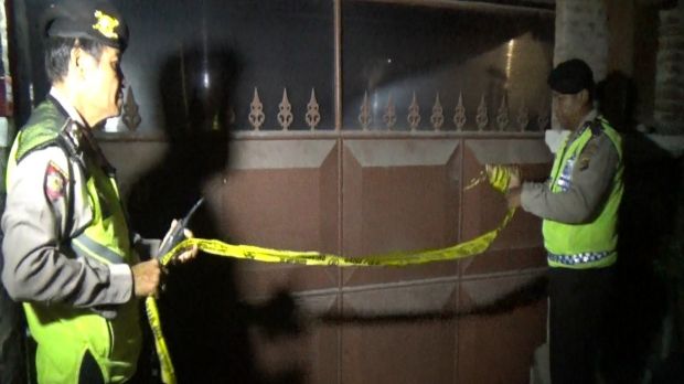 Police set up tape outside of the rented Sanur villa where the victim had been staying. 