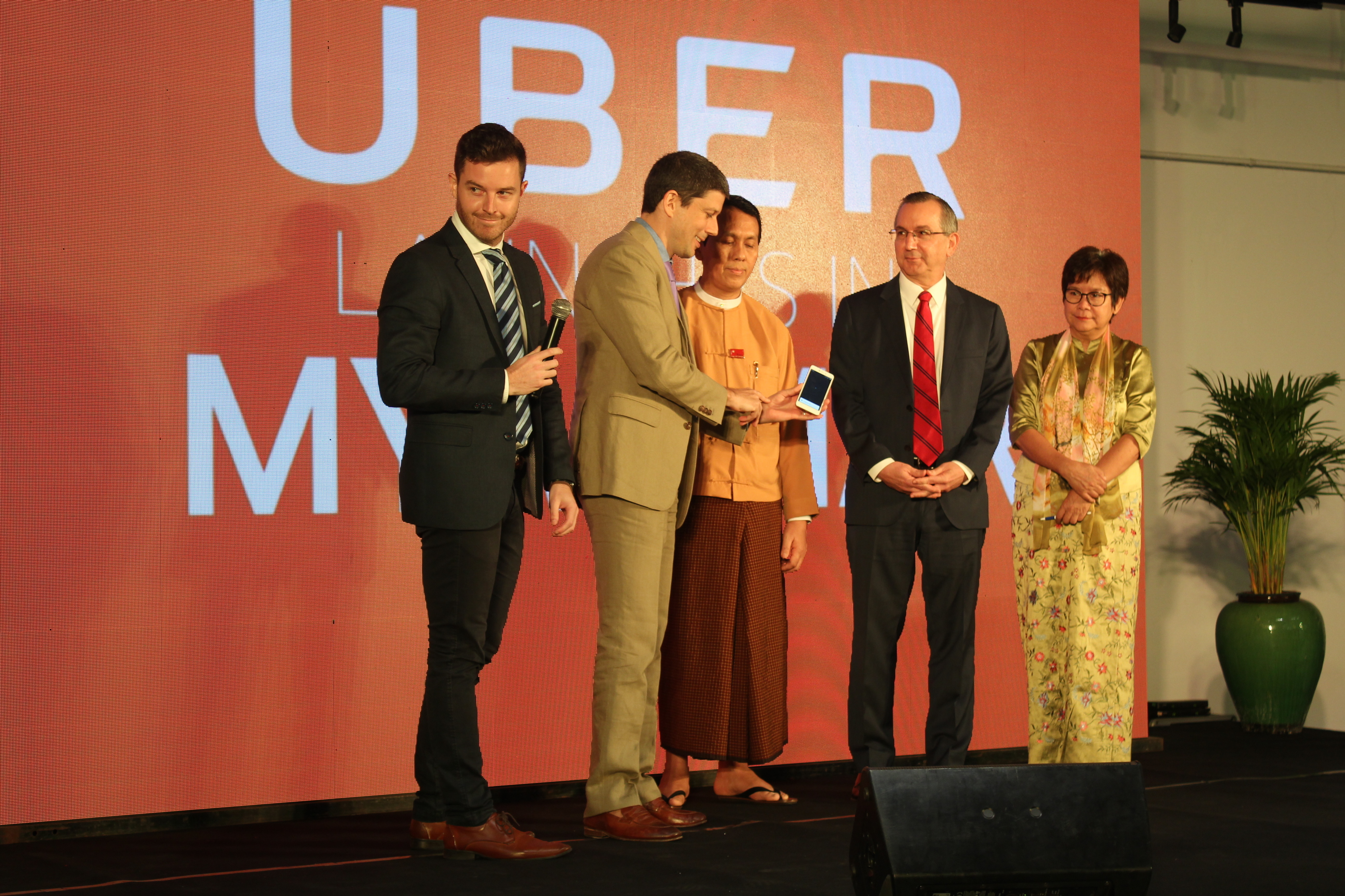 Yangon Region Chief Minister U Phyo Min Thein, US Ambassador Scot Marciel, and Yangon Region Minister for Transport and Communication Daw Nilar Kyaw appear on stage with Uber managers Mike Brown and Sam Bool on May 11, 2017. Photo: Jacob Goldberg