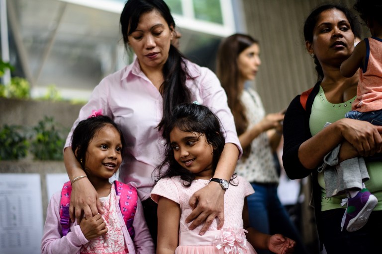 Sri Lankan refugee Nadeeka (R) holds her baby boy Danath as her daughter Sethumdi (front C) stands with Keana (front L), daughter of Filipino refugee Vanessa Rodel (back C), as they meet the press outside the Immigration Tower in Hong Kong on May 15, 2017. A group of refugees who sheltered fugitive whistleblower Edward Snowden in Hong Kong are facing deportation after the city’s authorities rejected their bid for protection, their lawyer said on May 15. AFP PHOTO / ANTHONY WALLACE