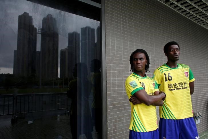 Solomon Nyassi (L), 26, from Gambia, a member of All Black FC, waits before joining a local team for a friendly match in Hong Kong, May 21, 2017. The team, All Black FC, is the first of its kind in the former British colony and offers a rare opportunity for refugees from more than 10 mostly African countries to integrate with residents. Photo: Bobby Yip/Reuters