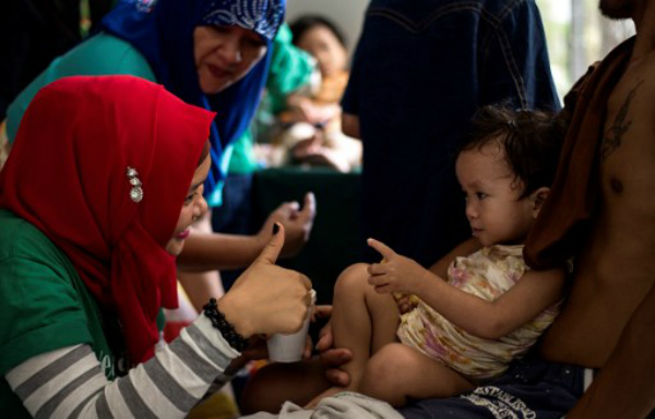 A volunteer doctor gives the thumbs up to 2 years old Manequin Lasola who was trapped for 11 days with her father Julio Lasola at Pangarungan Village in Marawi City, PHOTO: Noel Celis/AFP