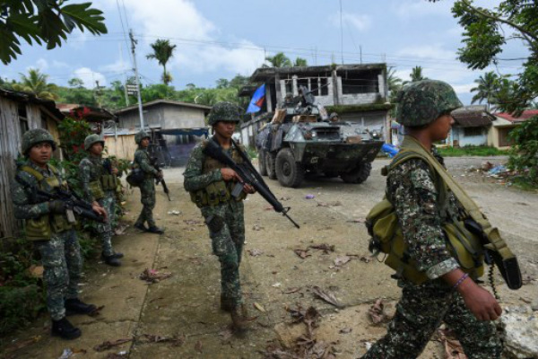 Philippine marines walk next to their V-300 light wheeled armoured vehicle after engaging Islamist militants at in Marawi, on the southern island of Mindanao on June 2, 2017. PHOTO: Ted Aljibe/AFP