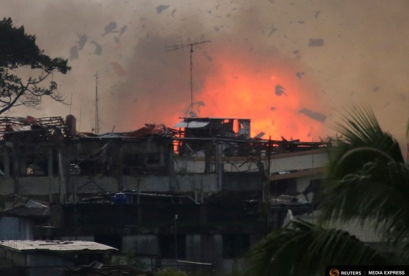 Debris and fire is seen after an OV-10 Bronco aircraft released a bomb, during an airstrike, as government forces continue their assault against insurgents from the Maute group, who have taken over large parts of Marawi City, Philippines. REUTERS/Romeo Ranoco