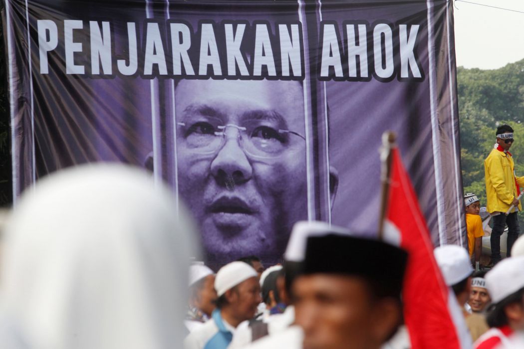 Indonesian protesters chant in front of a poster of Basuki Tjahaja Purnama, known by his nickname Ahok, as they march down the capital city’s main street after a demonstration at Jakarta’s National Monument Park on December 2, 2016. More than 100,000 Indonesian Muslims protested on December 2, 2016 against Jakarta’s Christian governor, the second major demonstration in a matter of weeks as conservative groups push for his arrest on accusations of insulting Islam. GOH CHAI HIN / AFP
