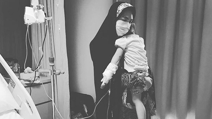 Oki Setiana Dewi carrying her daughter who suffered from measles. Photo: Instagram/okisetianadewi