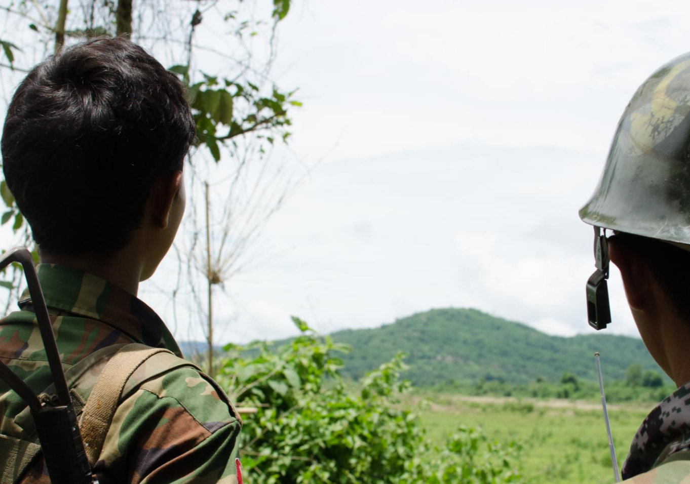 Two soldiers from the Kachin Independence Army  look out at the hills near Laiza, in an area of Kachin State controlled by the KIA, June 2013. Photo: Amnesty International / Daniel Quinlan
