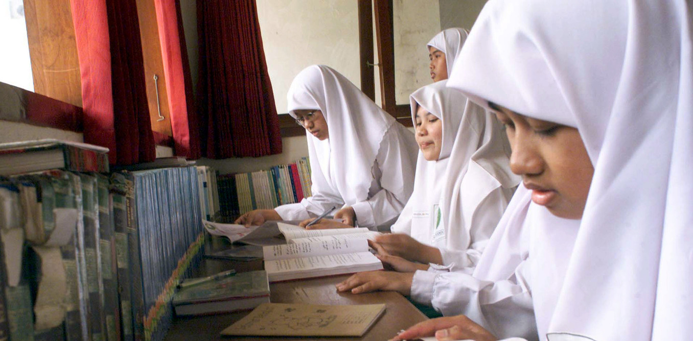 Indonesian female Muslim students read books in a library owned by Al
Mukmin boarding school in Solo, central of Java on October 22, 2002. Photo: REUTERS/Dadang Tri
