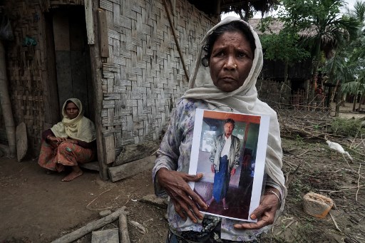 Moeyeyan Khatu, a Rohingya woman, holding a photograph of her son Atthu Suwan, who was stabbed and taken from his home in Buthidaung Township in northern Rakhine State. File Photo: AFP / HLA HLA HTAY