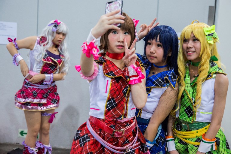 Cosplay fans (R) take selfies as comic book and gaming fans attend the annual Ani-Com and Games Fair in Hong Kong on July 28, 2017.
Tens of thousands were expected to attend the annual event on animation, comics and games, from July 28 to August 1. / AFP PHOTO / ISAAC LAWRENCE