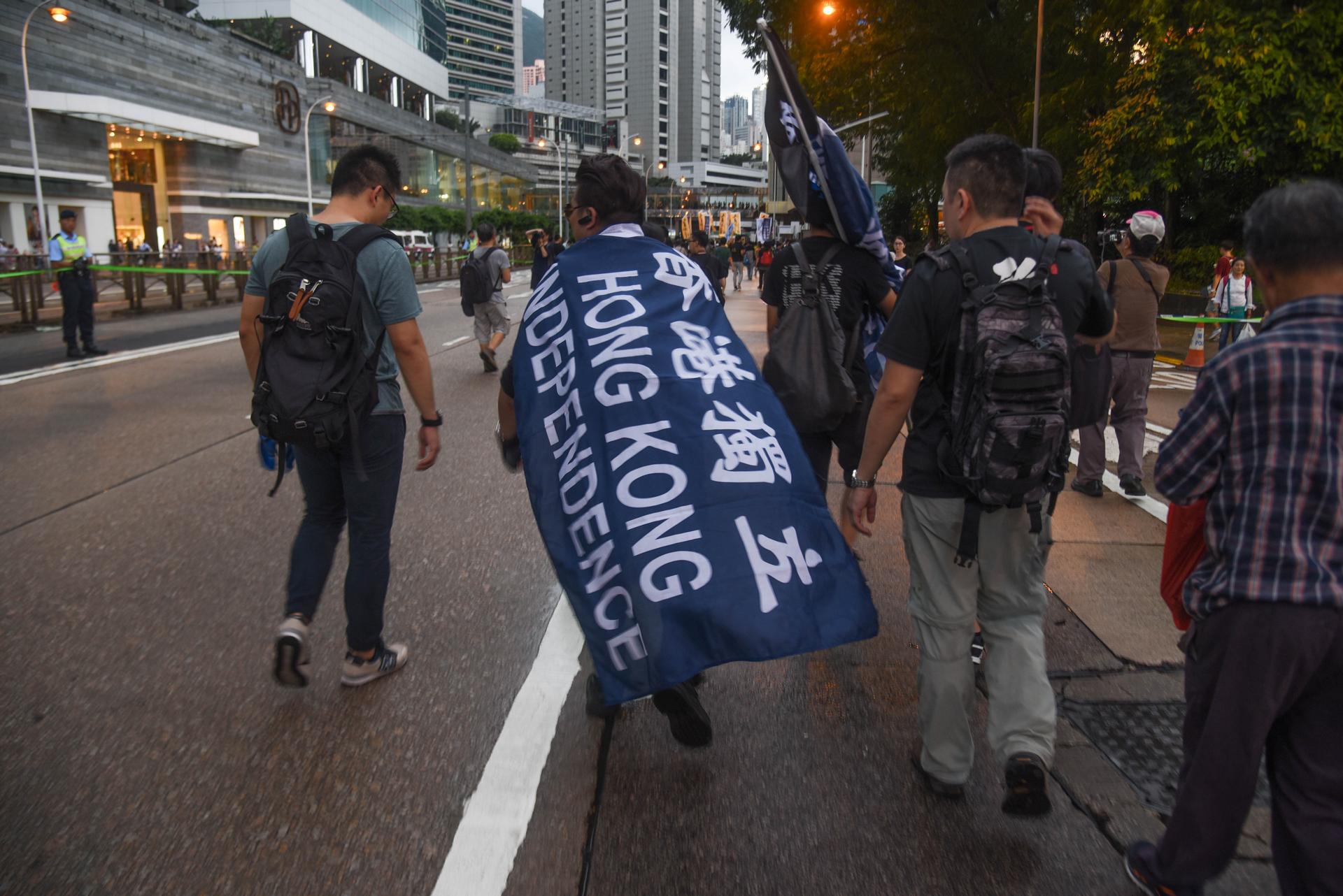 A protester wears a Hong Kong Independence flag at the annual democracy march, July 1, 2017. Photo: Annette Chan/Coconuts Media