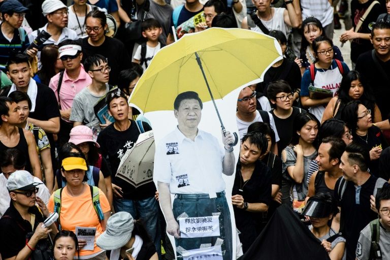A cardboard cut-out of China’s President Xi Jinping holding a yellow umbrella, a symbol of the 2014 ‘Umbrella Movement’ is carried during a protest in Hong Kong on July 1 — the 20th anniversary of the city’s handover from British to Chinese rule. AFP