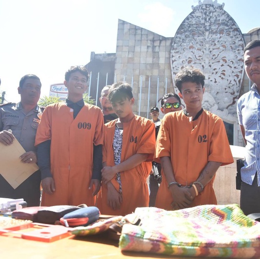 Police line up three suspects accused of committing crimes targeting tourists during a press conference held at the Bali Bombing Memorial on Thursday. Photo via Instagram @beritanya_bali