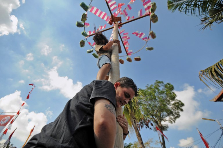 Convicted Australian drug smuggler Renae Lawrence (bottom C-black top) participates with other prisoners as they climb a pole during official ceremonies and games marking Indonesia’s 68th Independence Day at Kerobokan Prison on August 17, 2013. Lawrence was since transferred to the island’s Bangli Prison in 2014. Photo: Sonny Tumbelaka/AFP