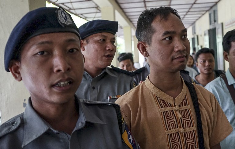Swe Win (C) is escorted to a court by police in Mandalay a day after he was detained at Yangon International Airport. Photo: AFP / Stringer