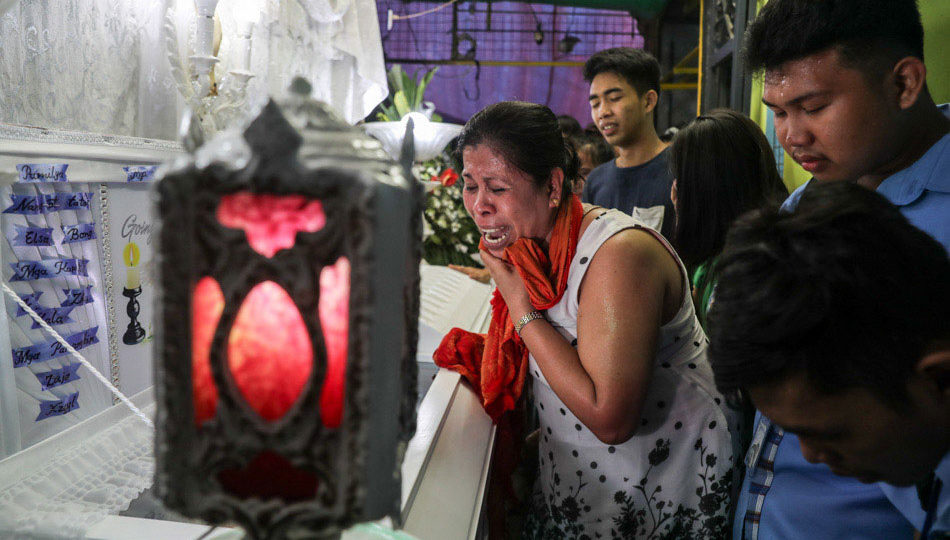Mrs. Lorenza Delos Santos, mother of Kian Delos Santos, weeps as she is surrounded by Kian’s classmates during the wake at the family’s residence in Caloocan, Friday. The Grade 11 student was killed during an anti-drug operation, when he allegedly fought arresting officers. PHOTO: Jonathan Cellona/ABS-CBN News