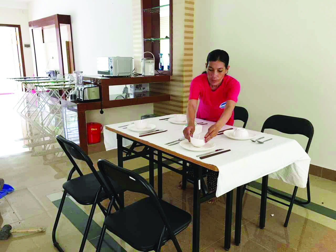 A Cambodian woman sets a table at a Phnom Penh training center on August 9, before beginning a new job in Hong Kong. Photo courtesy of the Phnom Penh Post