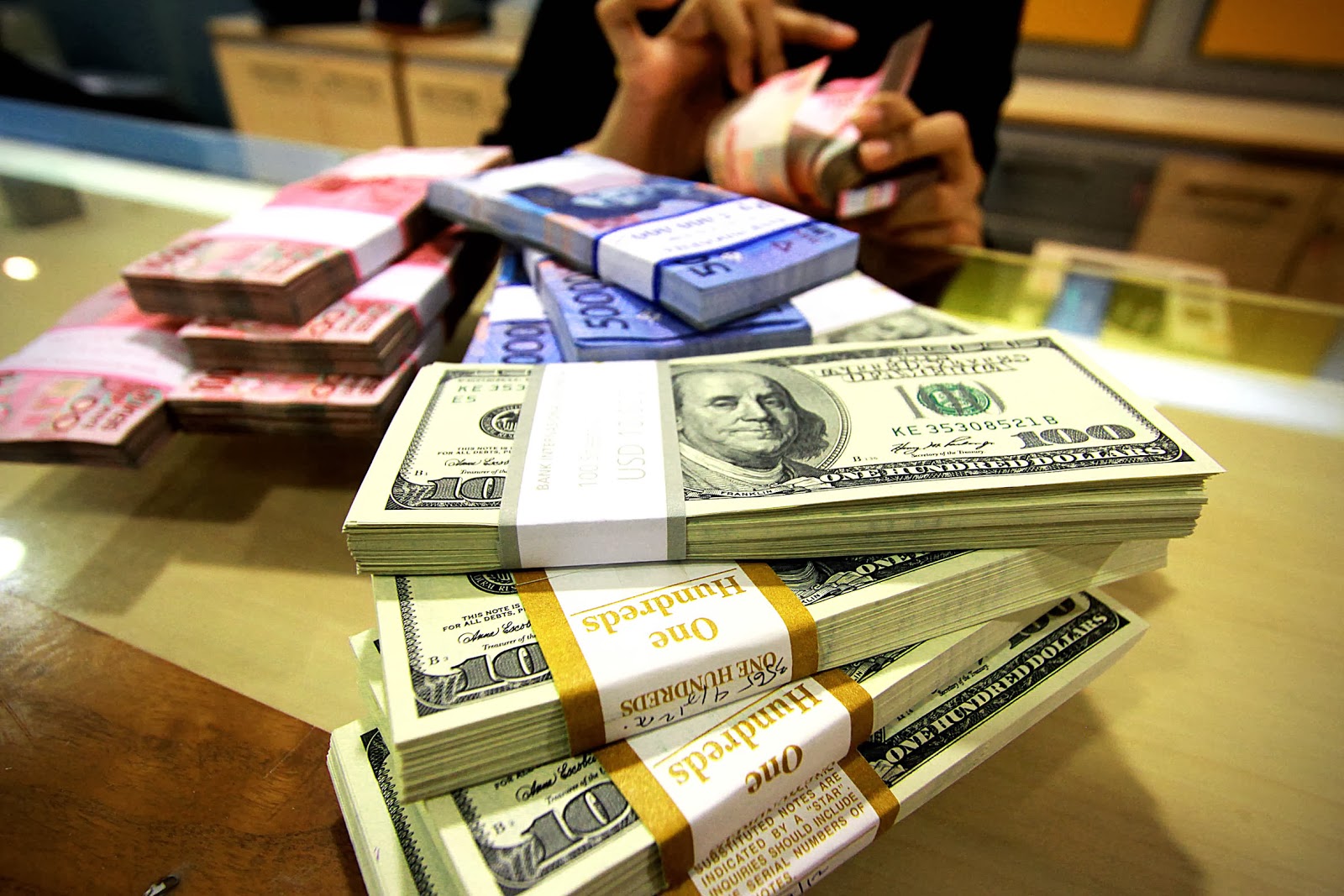 Stacks of the Indonesian rupiah next to stacks of the US dollar.