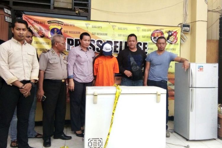 The woman identified as SA, who is suspected of killing her newborn, along with police and the two freezers in which she allegedly stored the body. Photo: North Kalimantan Polce